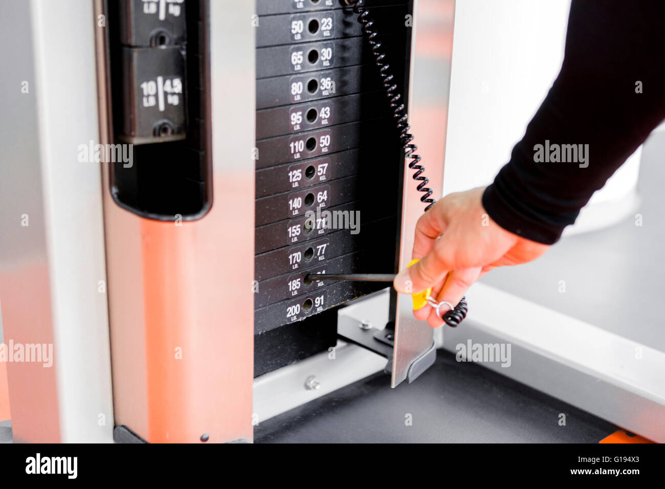 Nahaufnahme eines jungen Mannes, der das Gewicht während der Arbeit aus Auswahl Stockfoto