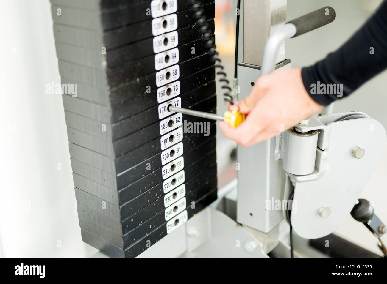 Nahaufnahme eines jungen Mannes, der das Gewicht während der Arbeit aus Auswahl Stockfoto