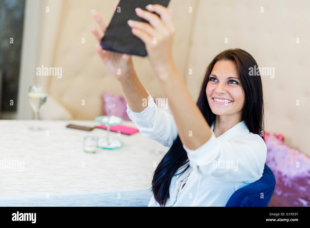 Schöne junge Frau, die unter ein Selfie von sich selbst in einem restaurant Stockfoto