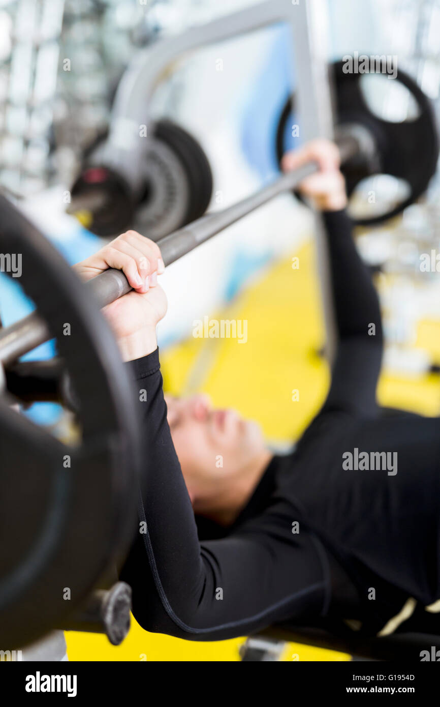 Nahaufnahme von jungen hübschen männlichen Übungen auf beim Bankdrücken Stockfoto