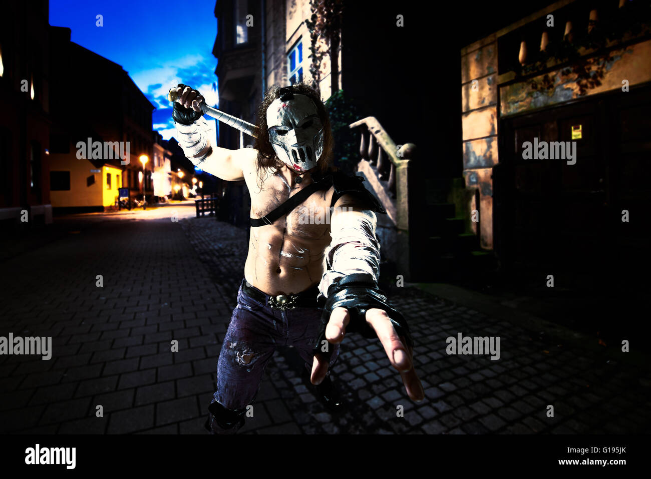 Kostümierte Helden als eine Straße Maniac mit einer Fledermaus. Casey Jones in Malmö Straße. Kombiniertes Bild - Studioarbeit wurde hinzugefügt, um reale Landschaften Stockfoto