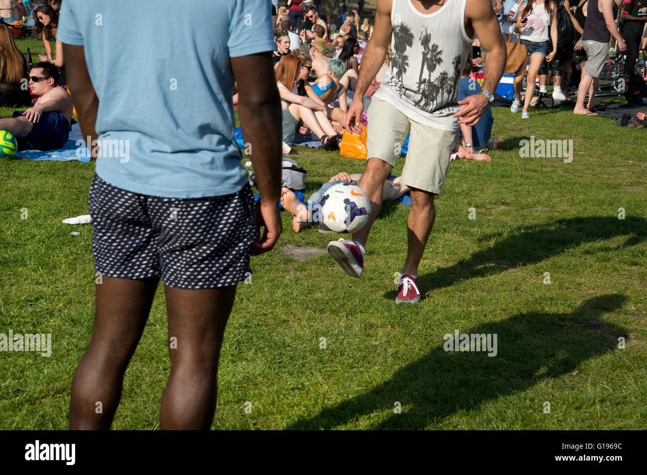 Hackney. London Fields Park. Sonntag Nachmittag in der Sonne. Zwei junge Männer spielen keepy uppy mit einem Fußball. Stockfoto