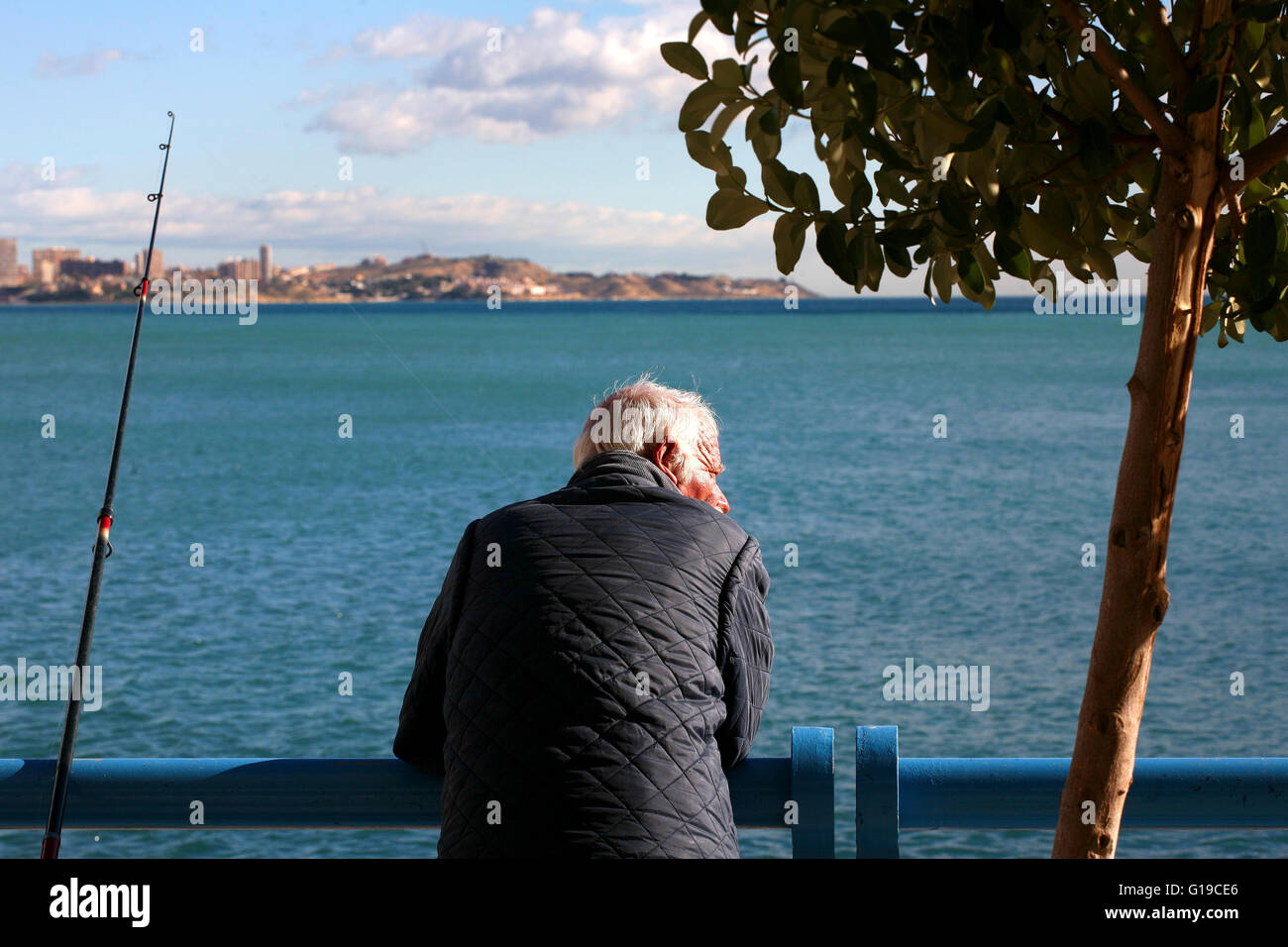 Costa Blanca Spanien Alicante Stadt Mann Angeln vom Felsen Playa del Postiguet Stockfoto
