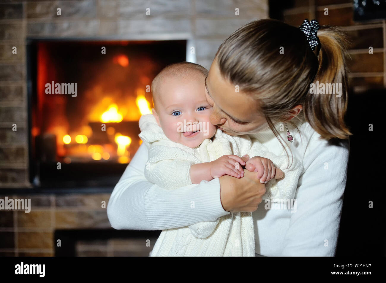 Mutter mit Baby zu Hause am Kamin Stockfoto