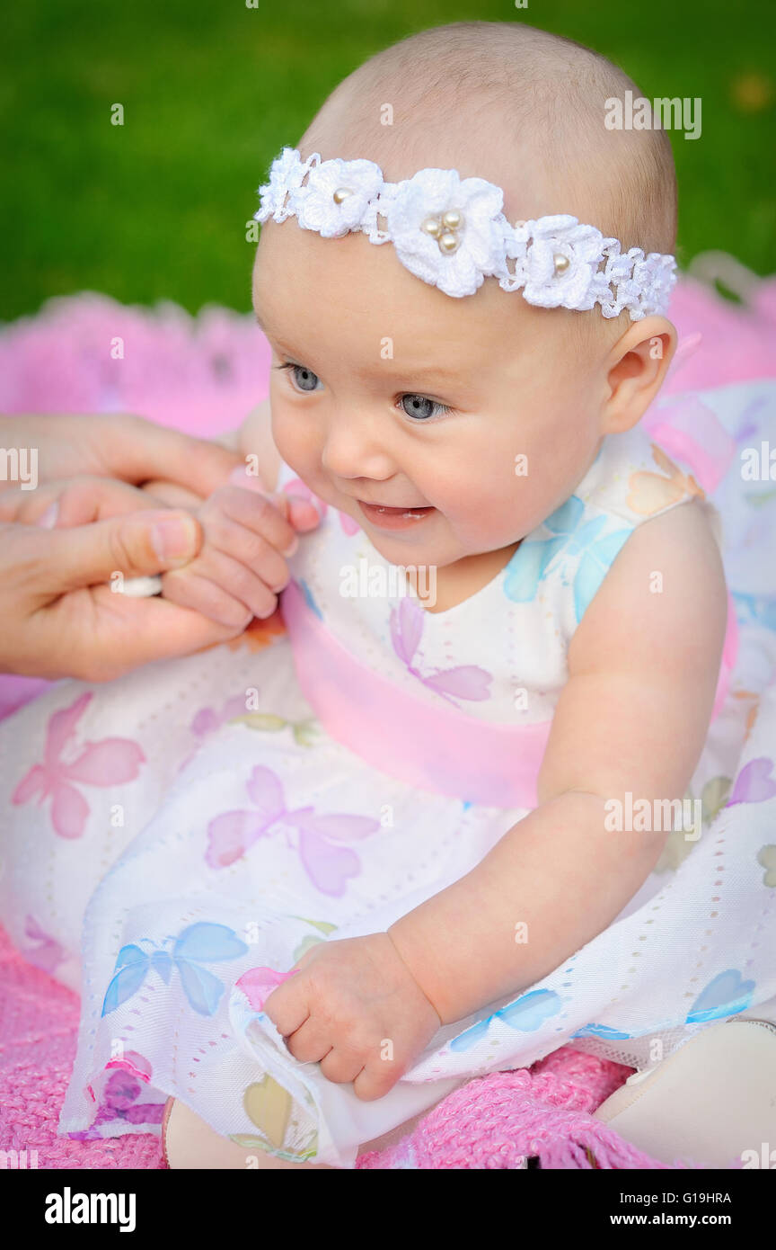 glücklich lächelnd fröhliche Babymädchen in Rosa Kapuze mit Ohren Stockfoto