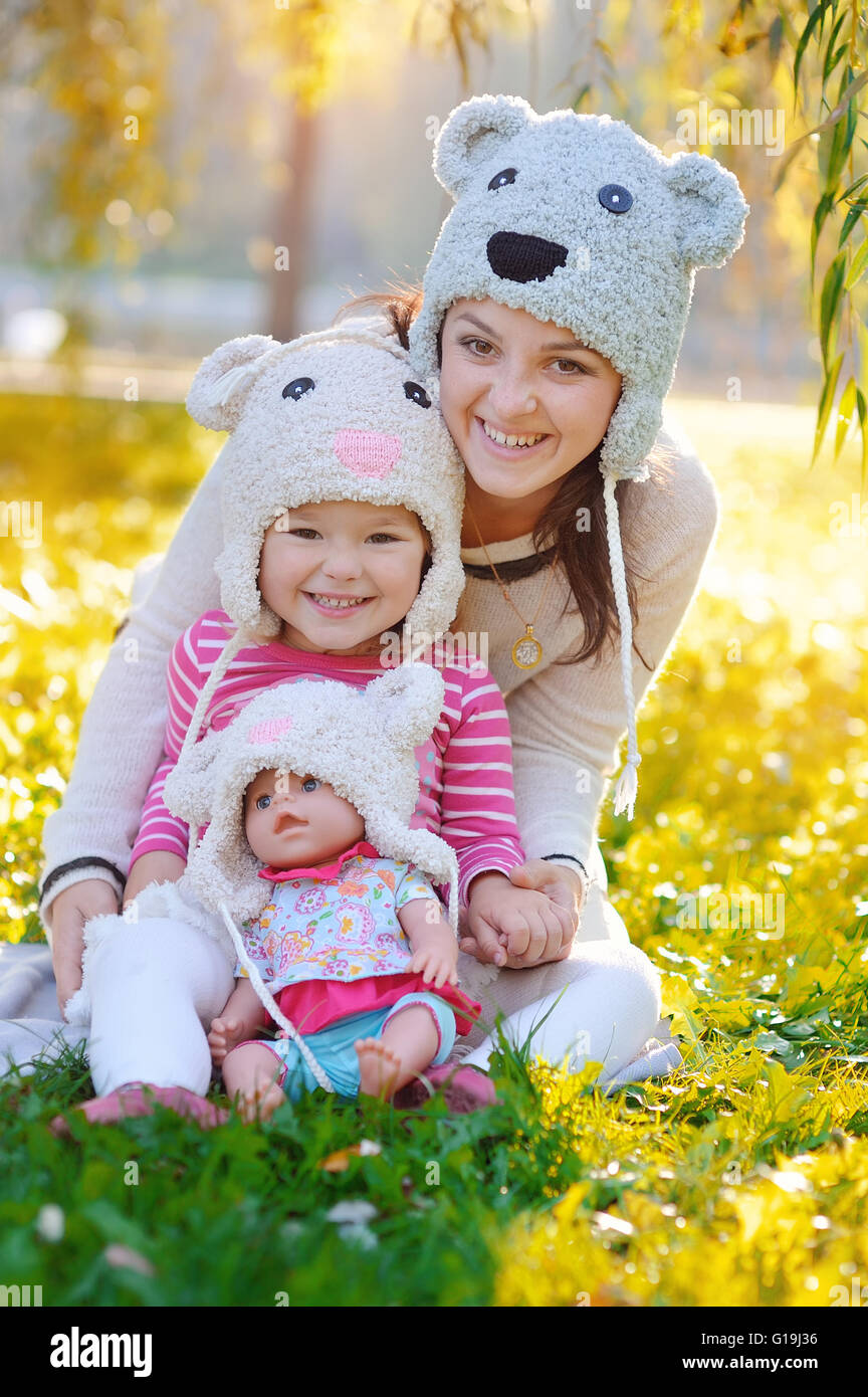 Mädchen mit einer Puppe in ihrer Mutter und Hüte Stockfoto