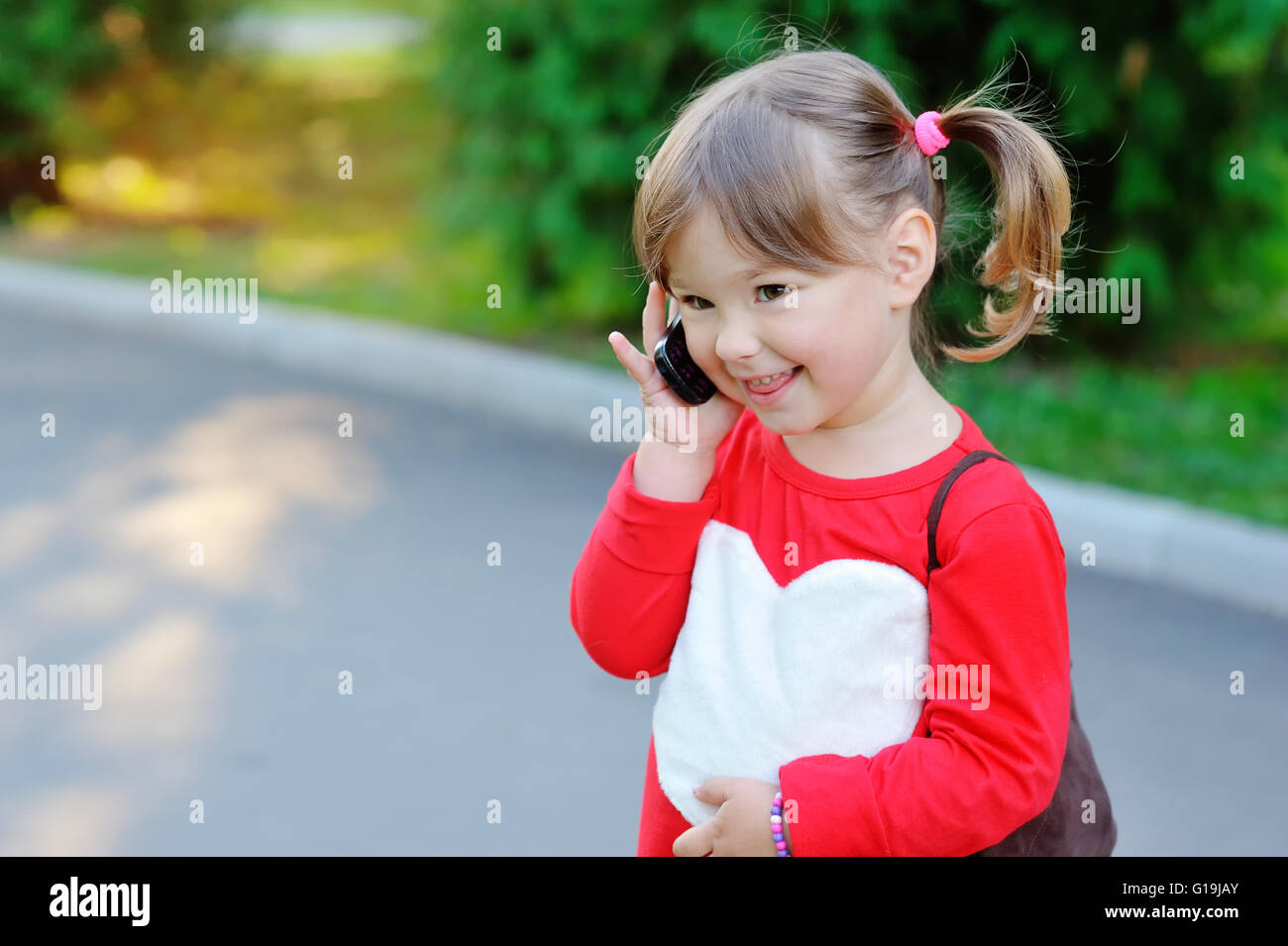 Outdoor Portrait der niedliche kleine Mädchen sprechen per Telefon Stockfoto