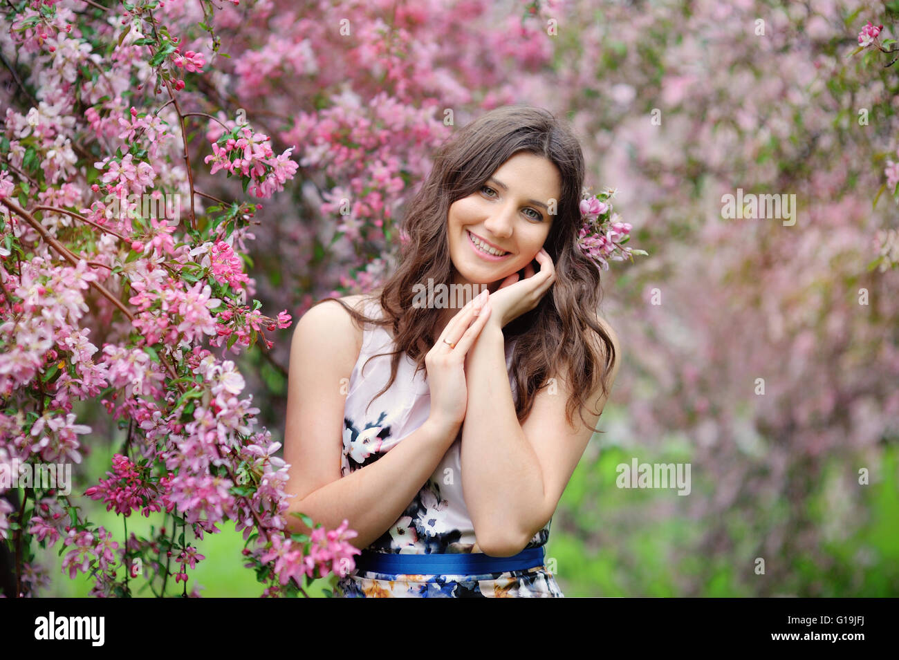 Schöne Mädchen im Frühlingsgarten unter den blühenden Bäumen mit pi Stockfoto