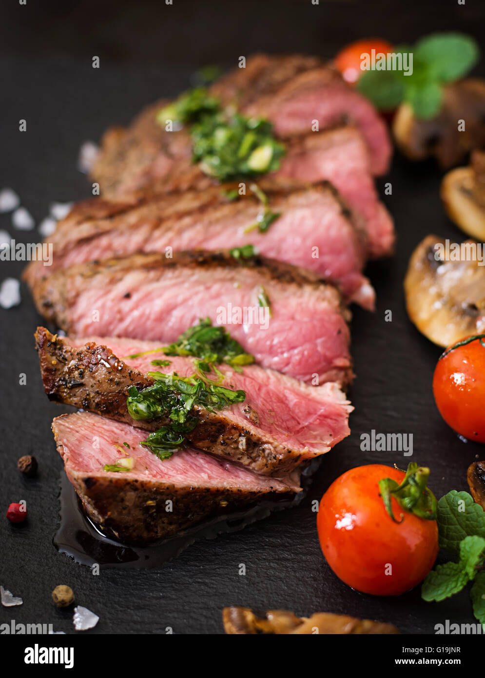 Saftiges Steak Medium selten Rindfleisch mit Gewürzen und gegrilltem Gemüse. Stockfoto