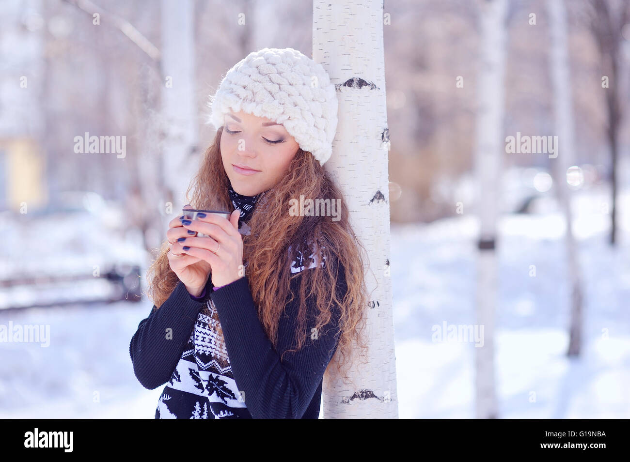 Junge Frau mit einer Tasse Heißgetränk in Winter park Stockfoto