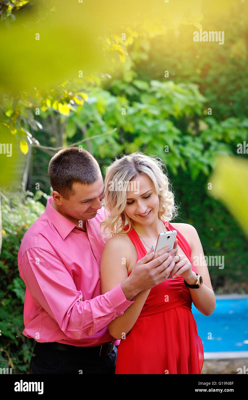 Porträt der jungen Paare, die Spaß mit Smartphones, im freien Stockfoto