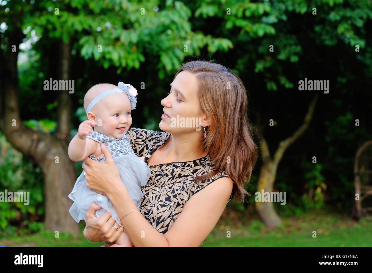 Porträt der lächelnde Mutter und Baby im freien Stockfoto