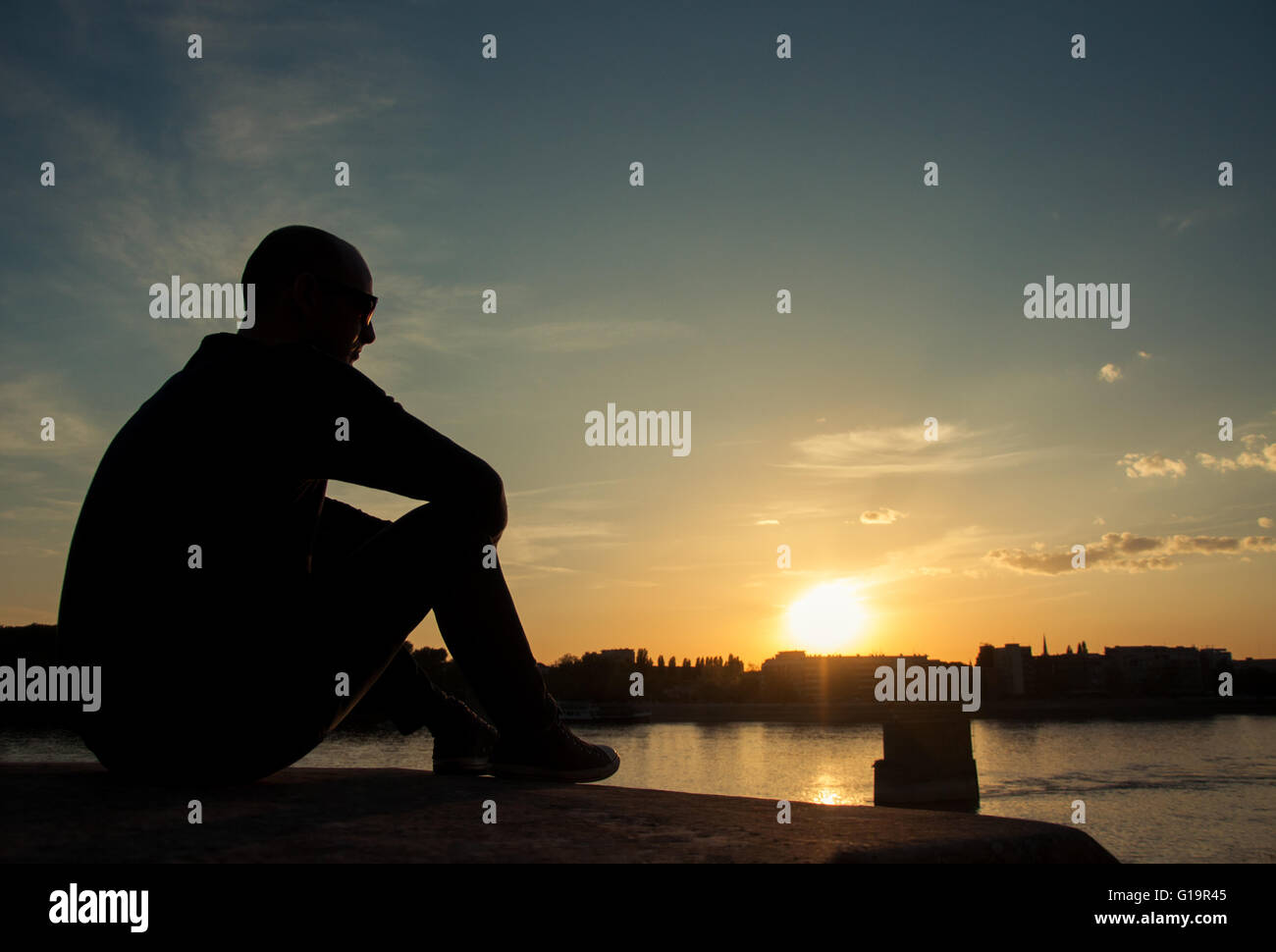 Mann-Silhouette, Sonnenuntergang über der Stadt Stockfoto