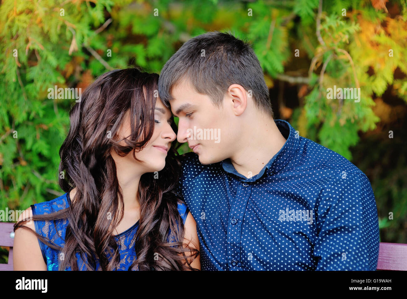 junges Paar in Liebe sitzt auf der Bank, einen romantischen Moment Stockfoto