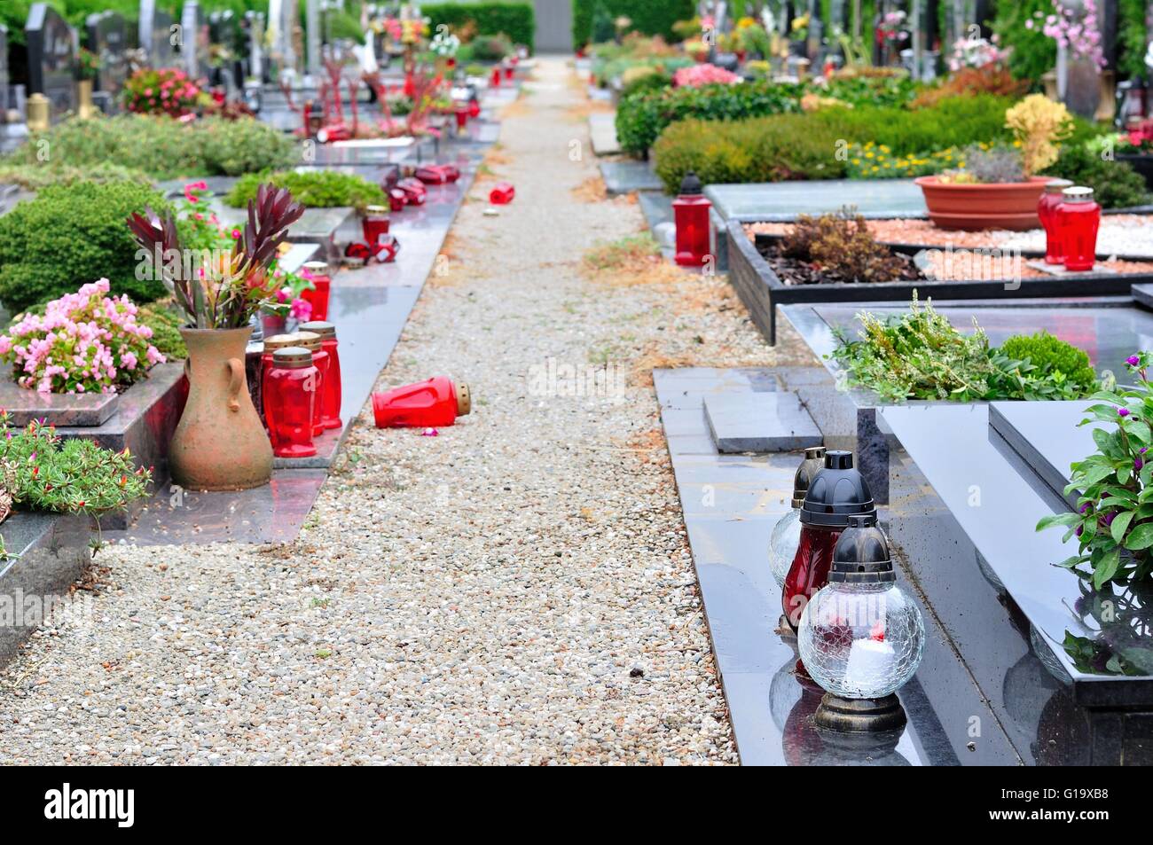 Blumen und Kerzen am Grab im Kirchhof Stockfoto
