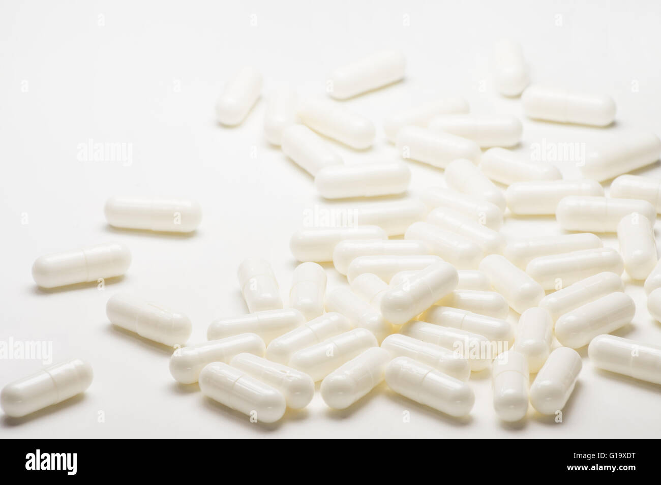 Verstreute weiße Medizin Kapseln Stockfoto