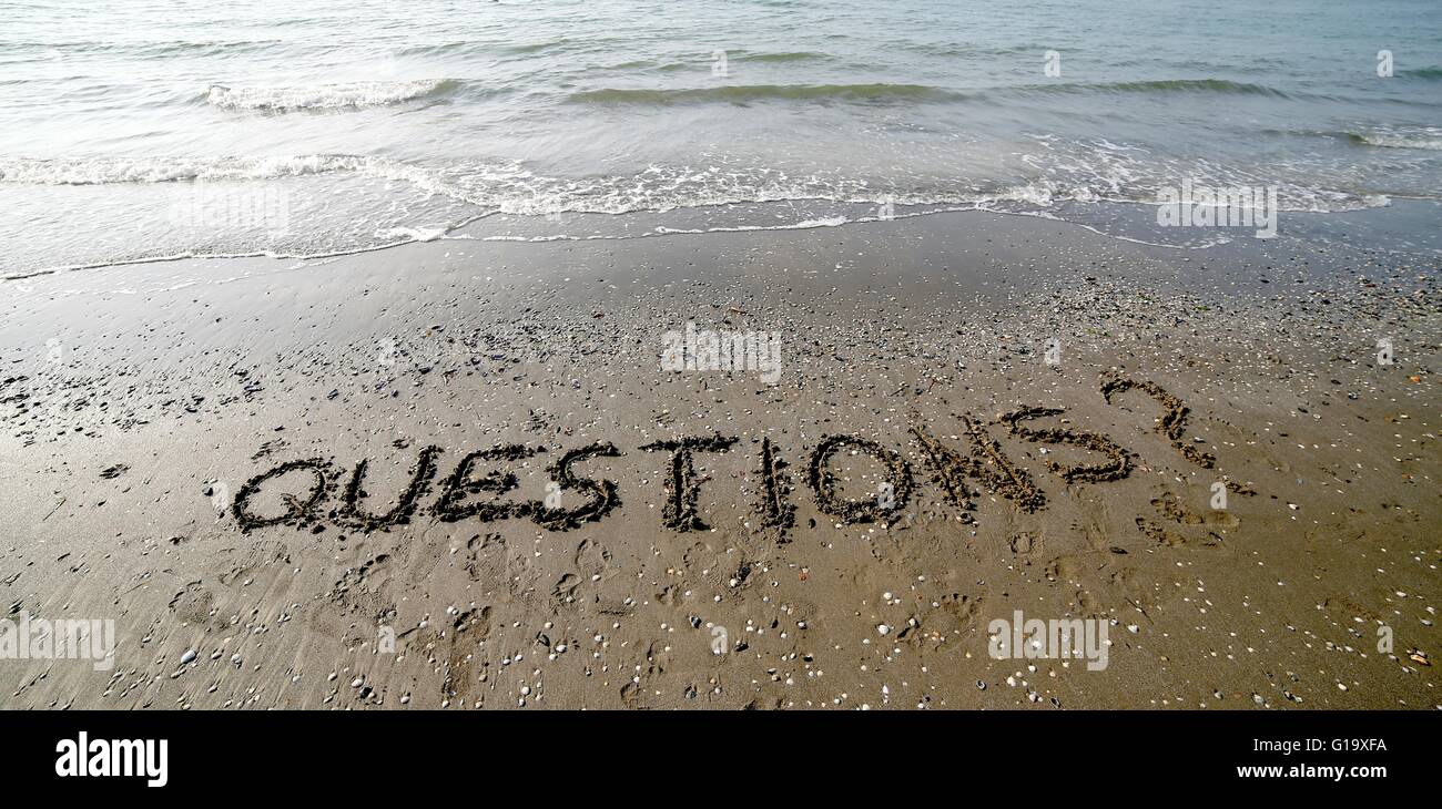 Geschrieben in großen Lettern auf dem Sand des Meeres im Sommer Fragen Stockfoto