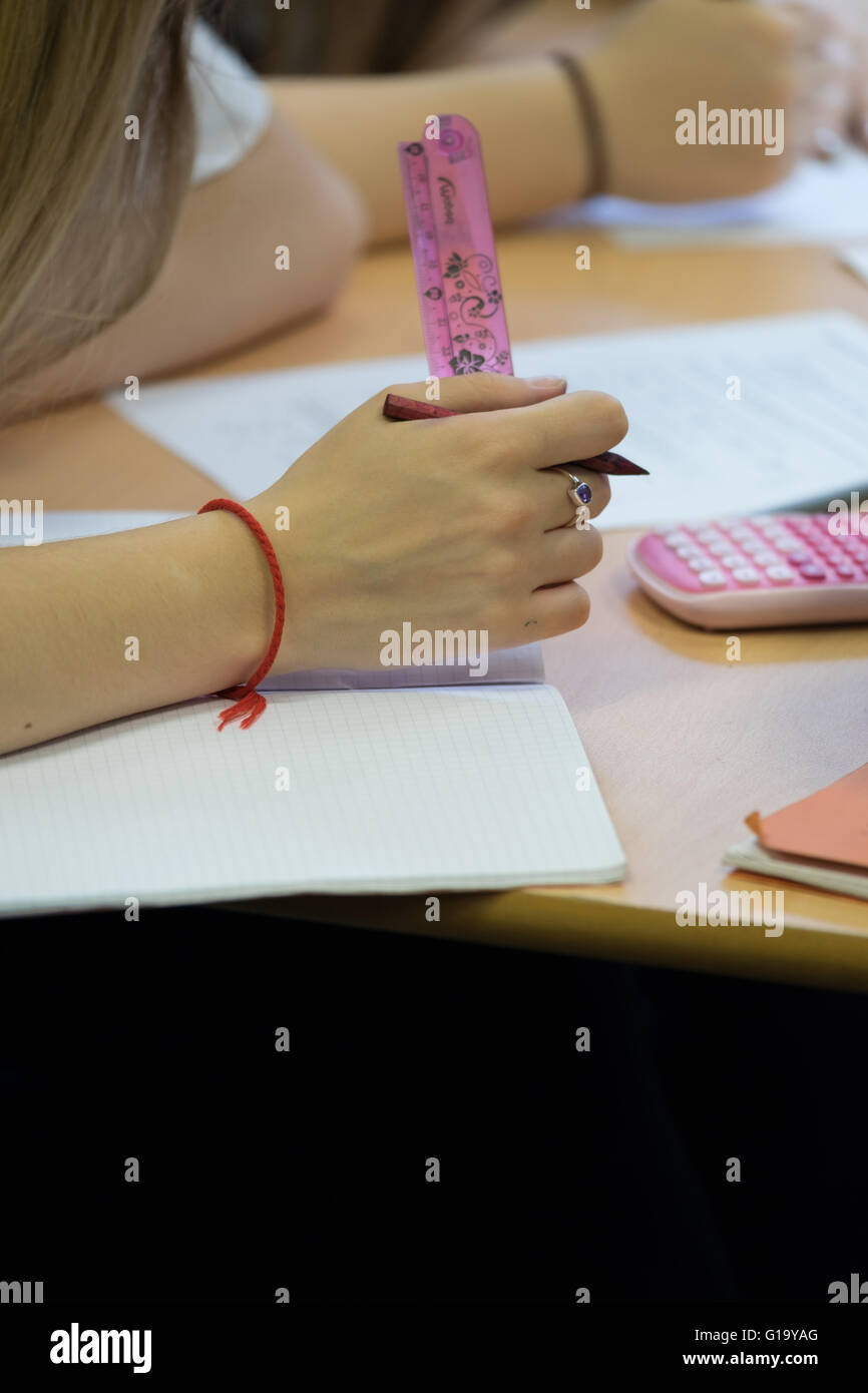Mädchens Hand hält einen rosa Herrscher in einer GCSE Prüfung in einer UK-Schule Stockfoto