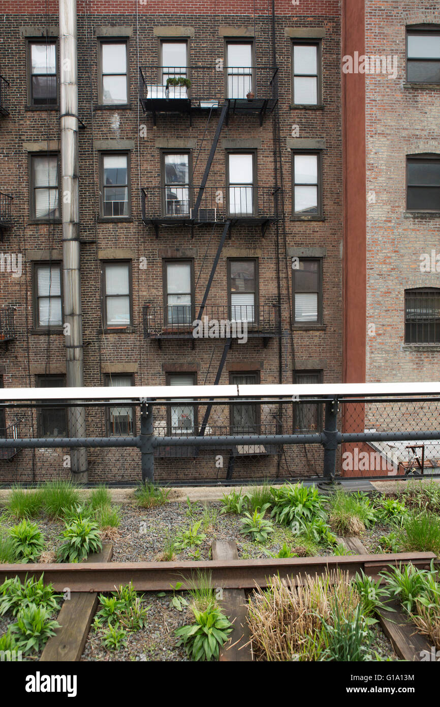 Ein Blick auf einem Mehrfamilienhaus mit traditionellen Feuerleitern aus der High Line in New York City, USA. Das Gebäude ist o gemacht. Stockfoto