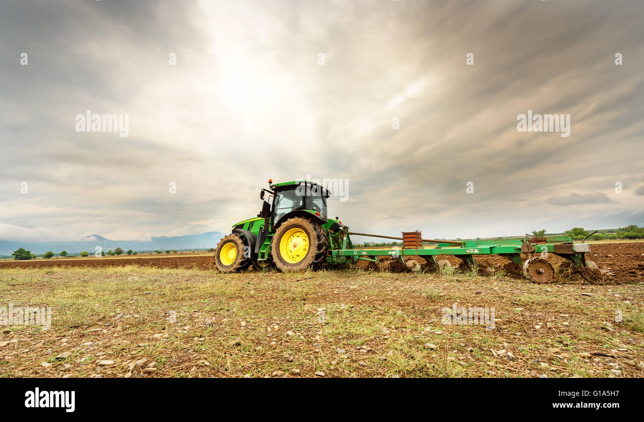 Karlovo, Bulgarien - 22. August 2015: Pflügen ein Feld mit John Deere 7230R Traktor. John Deere 8100 wurde im Jahr 1995 hergestellt. Stockfoto