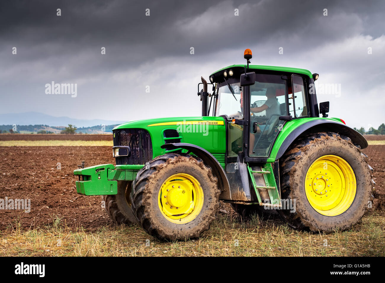 Karlovo, Bulgarien - 22. August 2015: Pflügen ein Feld mit John Deere 6930 Traktor. John Deere 8100 wurde in 1995 - hergestellt. Stockfoto