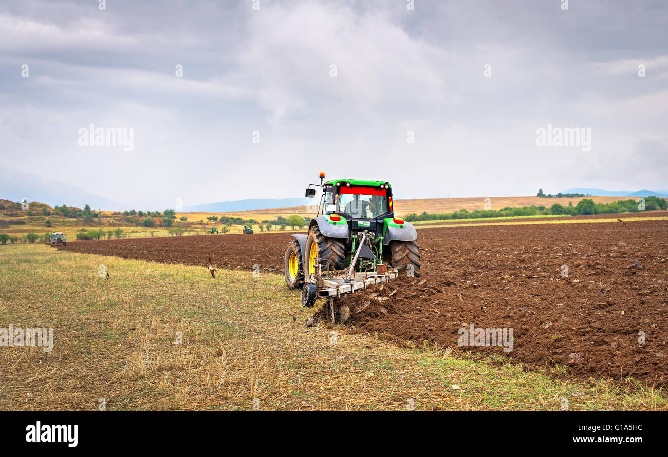 Karlovo, Bulgarien - 22. August 2015: Pflügen ein Feld mit John Deere 7230R Traktor. John Deere 8100 wurde im Jahr 1995 hergestellt. Stockfoto