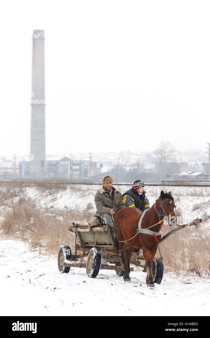 Leute mit einem Pferdewagen auf einer verschneiten Landstraße entlang der Bahnlinie in Ciurea in der Nähe von Iasi, Rumänien Stockfoto