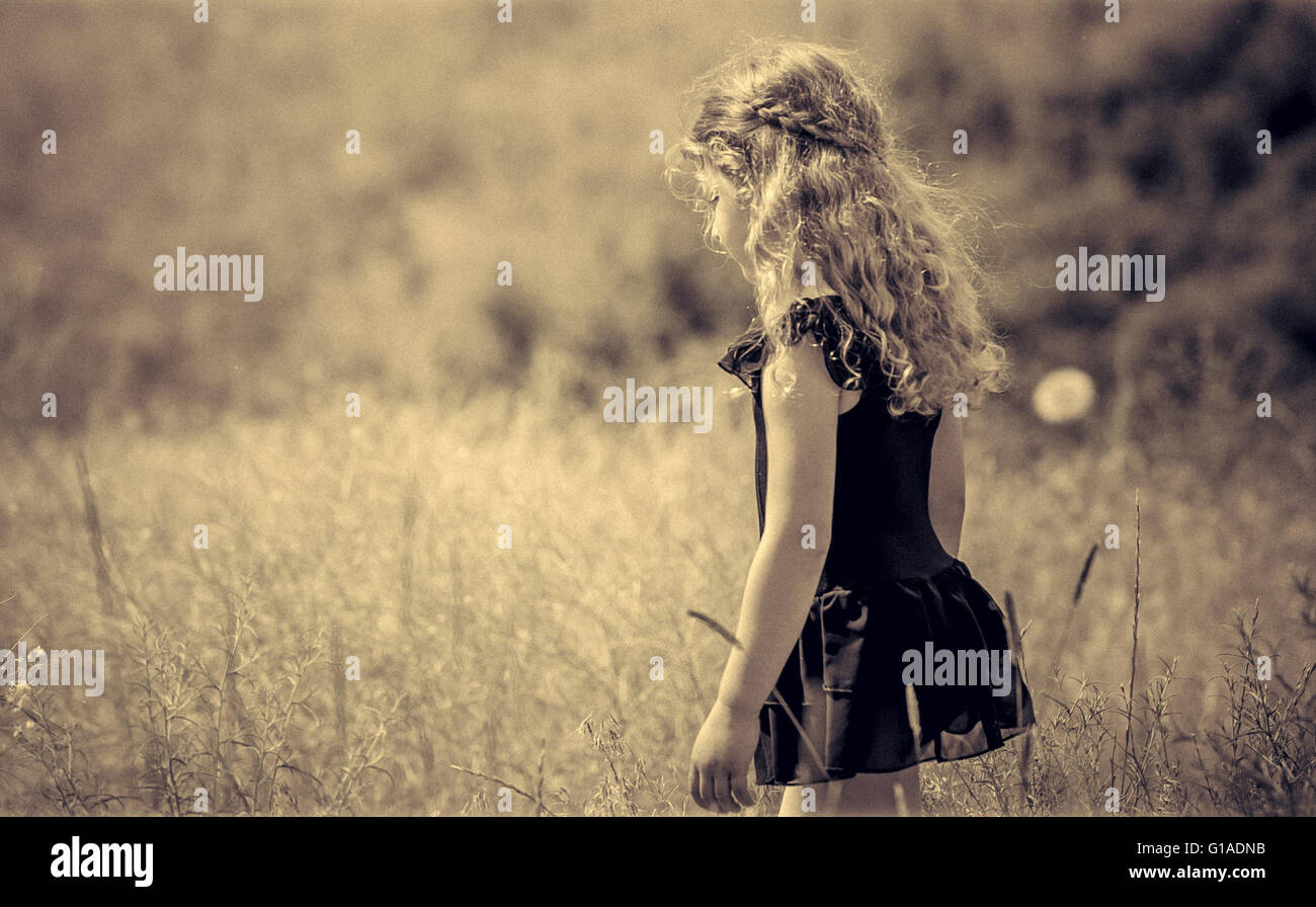Bild eines jungen Mädchens mit schönen geflochtenen Haaren ein Spaziergang zwischen hohen Gräsern, die Einsamkeit zu genießen Stockfoto