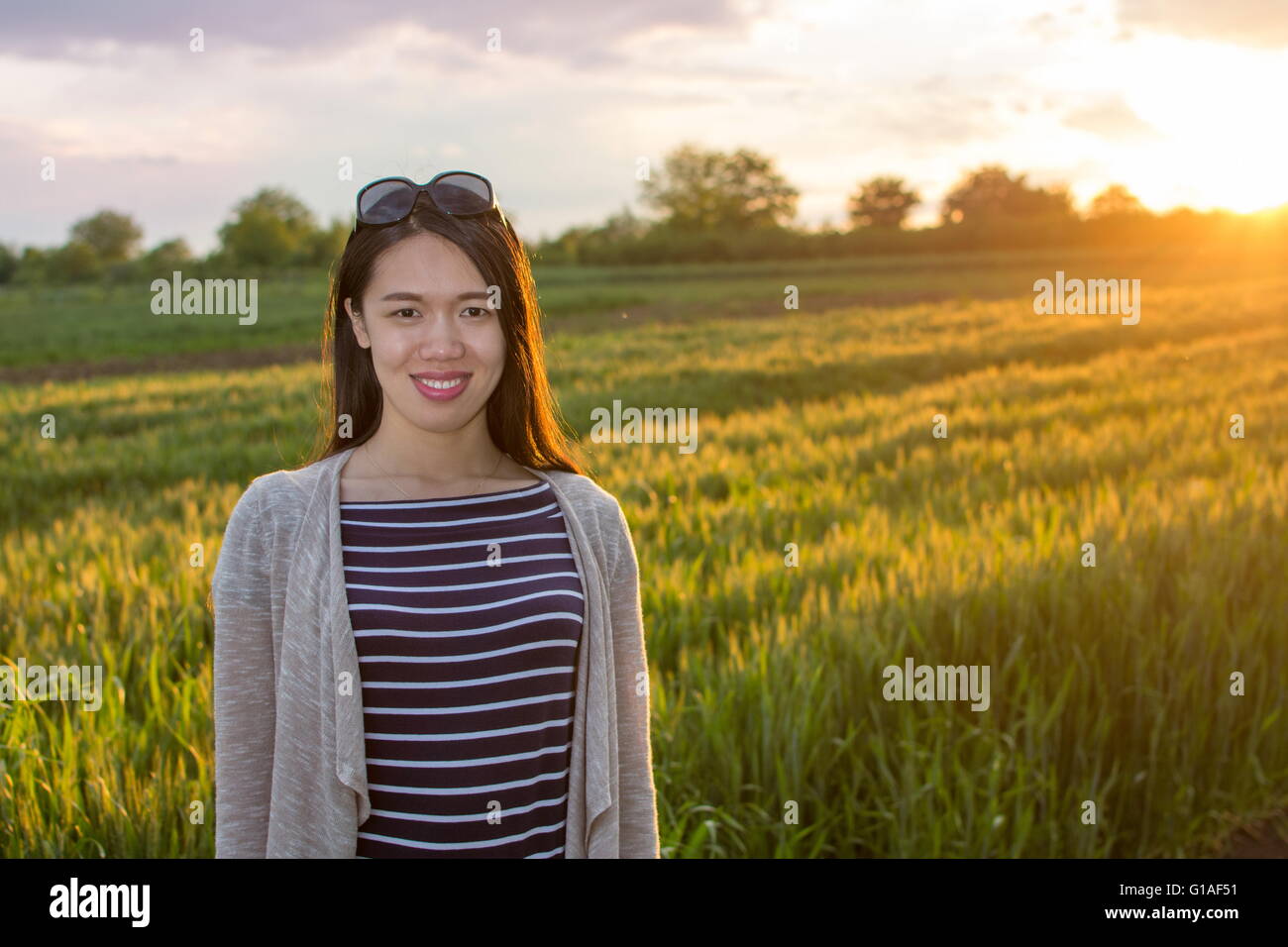 Junge glückliche Frau in einem Feld von Weizen Stockfoto