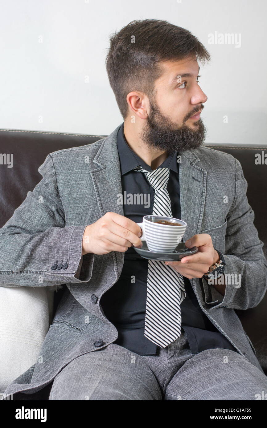 Geschäftsmann im Anzug mit einer Tasse Kaffee Stockfoto