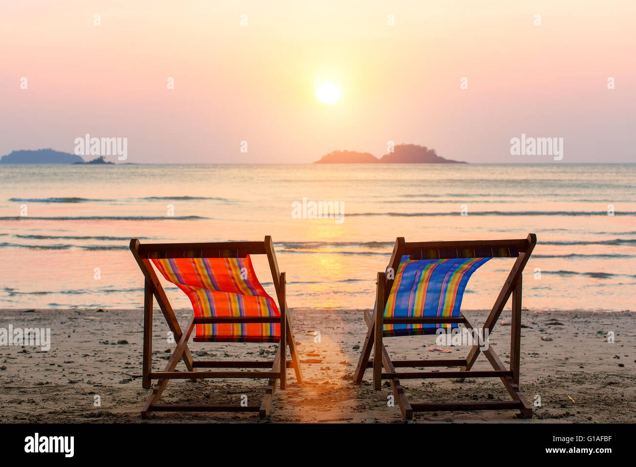 Zwei Liegestühle am sunset Beach. Stockfoto