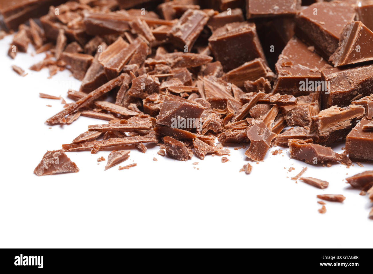 Stapel gebrochen und rasierte Schokoladenstücke, Isolated on White Background. Stockfoto