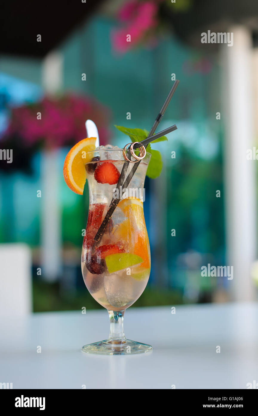 Cocktail mit Fruchtstückchen und Trauringe auf einem cocktail Tube. Stockfoto