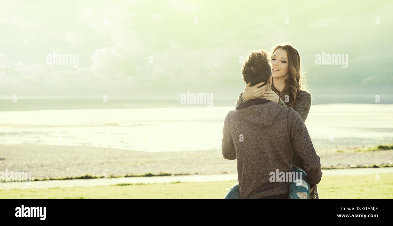 Glückliche junge Liebespaar am See im Sonnenlicht, Liebe und Beziehungen Konzept umarmt Stockfoto