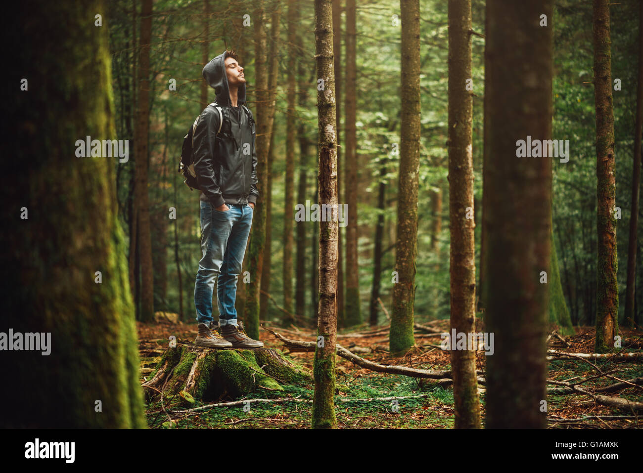 Vermummte jungen Mann im Wald stehen und erkunden, Freiheit und Natur-Konzept Stockfoto
