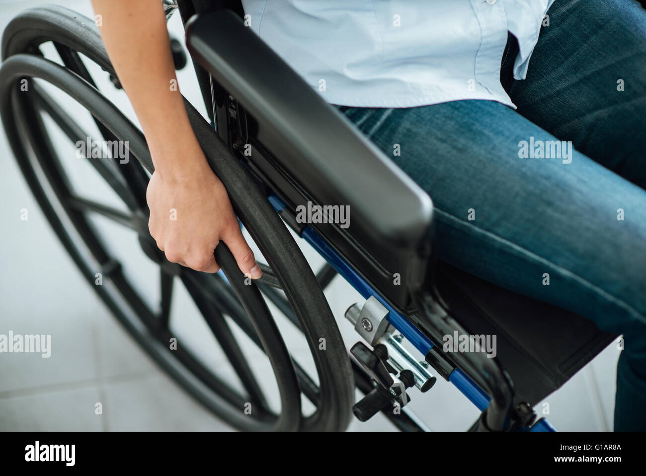 Frau im Rollstuhl Hand am Rad in der Nähe von Behinderung und Handicap-Konzept Stockfoto