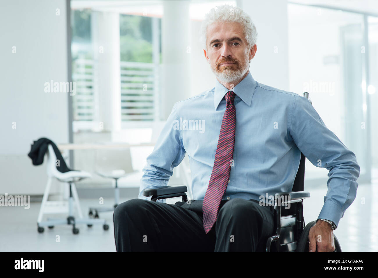 Erfolgreicher zuversichtlich Geschäftsmann im Rollstuhl lächelnd in die Kamera, Karriere und Behinderung Konzept zu überwinden Stockfoto