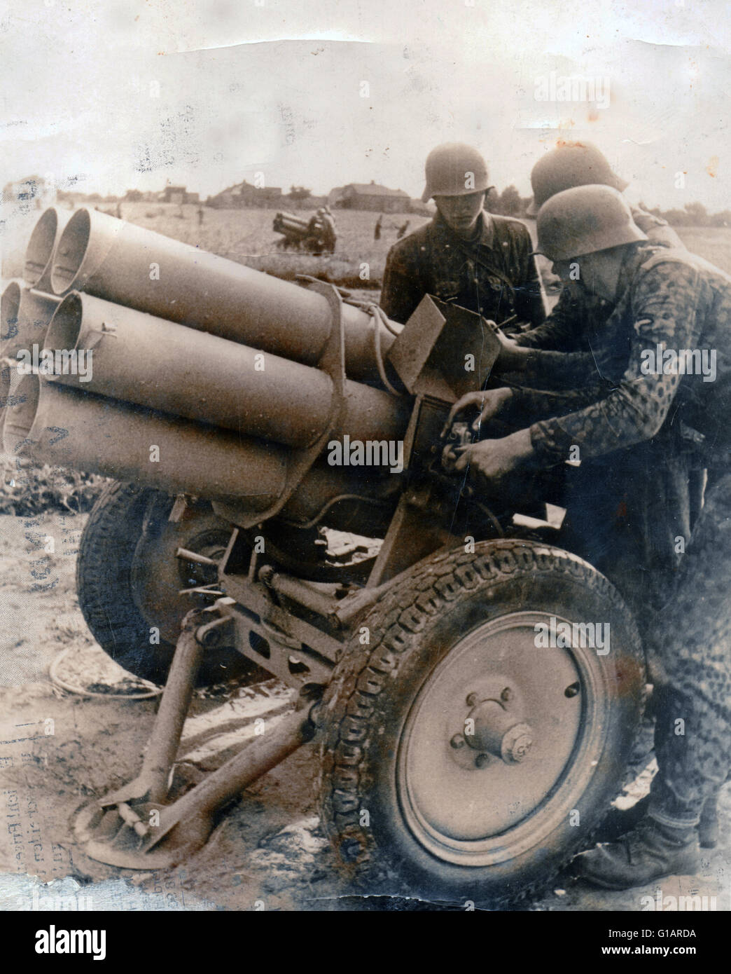 Zweiter Weltkrieg / Waffen SS Soldaten gekleidet Tarnmuster Drill Bereitet einen Nebelwerfer vor, der auf die Russische Front 1944 feuern soll Stockfoto