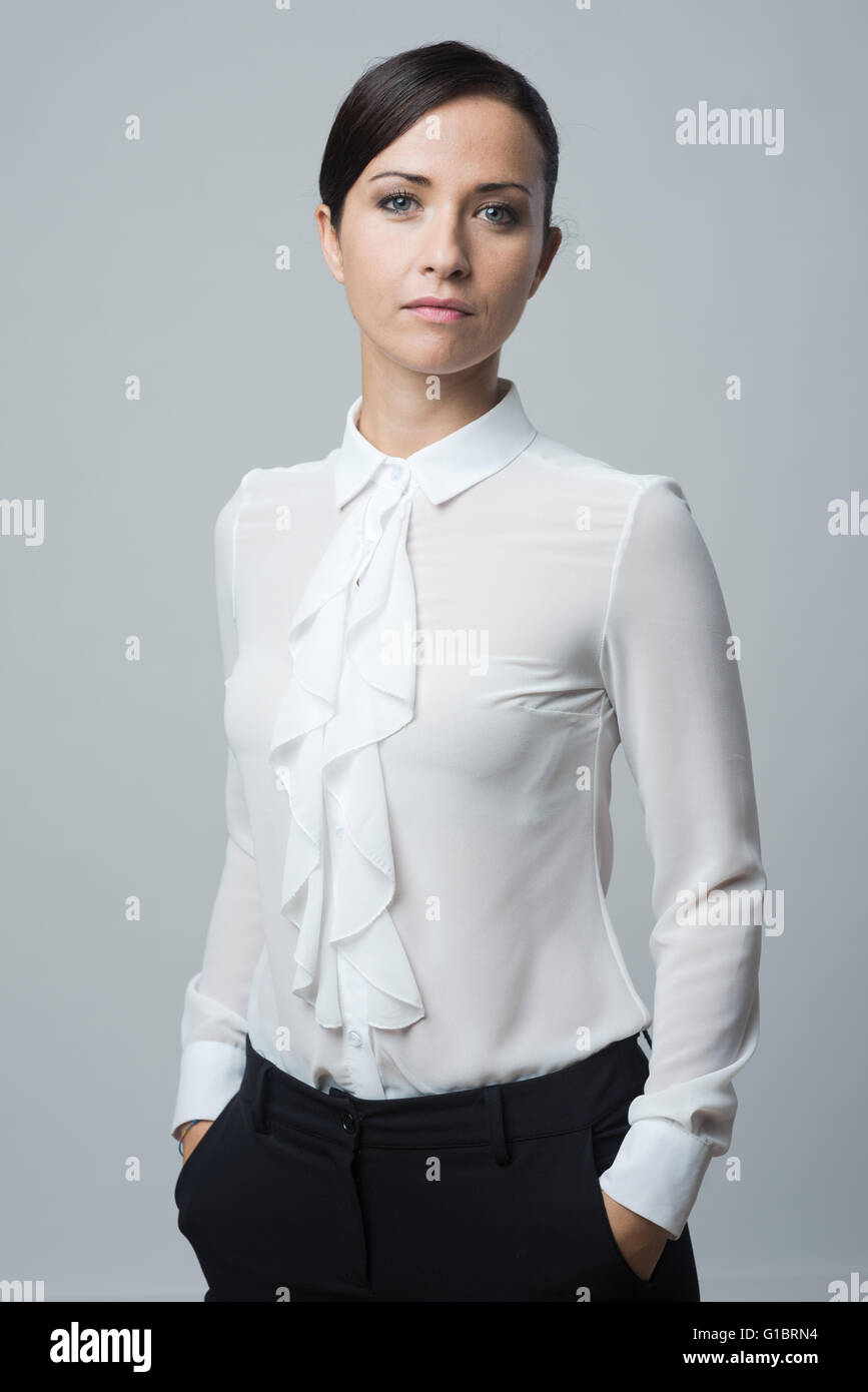 Selbstbewusste Frau in elegantes Hemd mit Händen in den Taschen, starke Haltung. Stockfoto