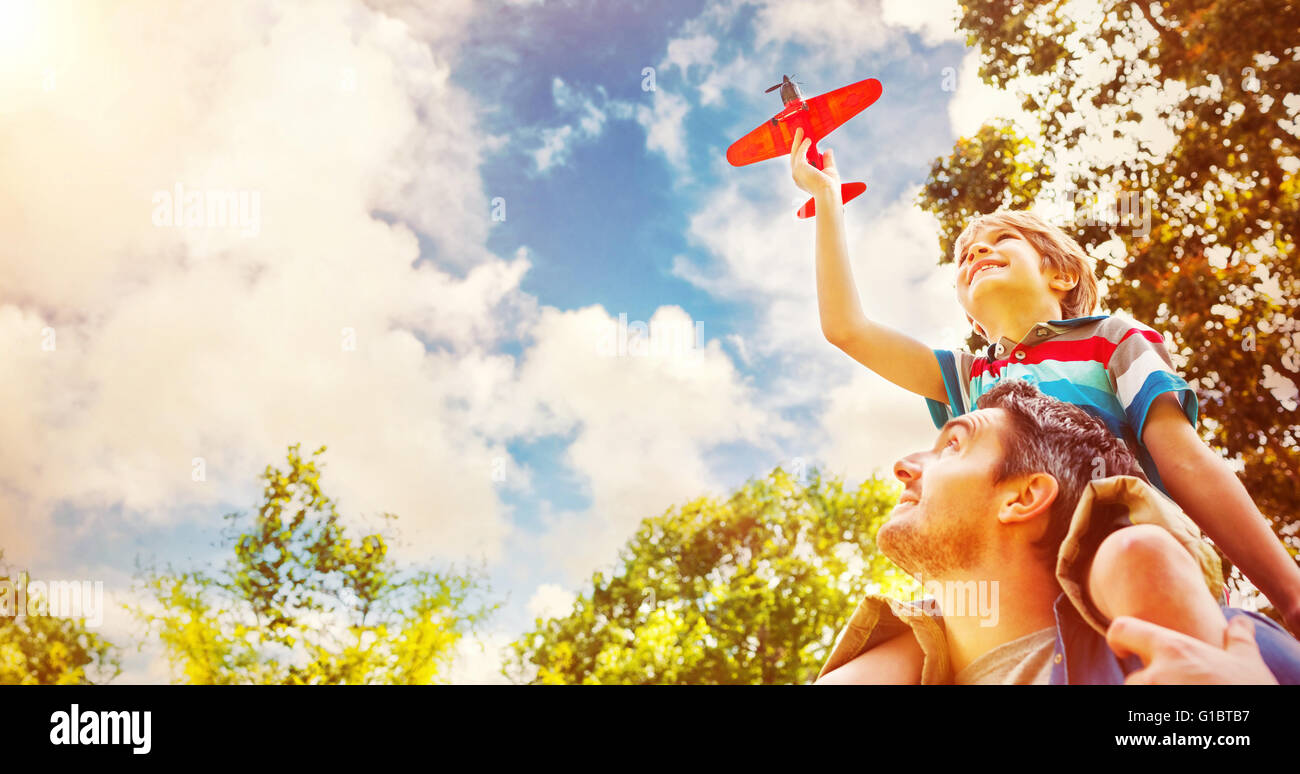 Junge mit Spielzeug Flugzeug sitzen auf den Schultern der Väter Stockfoto