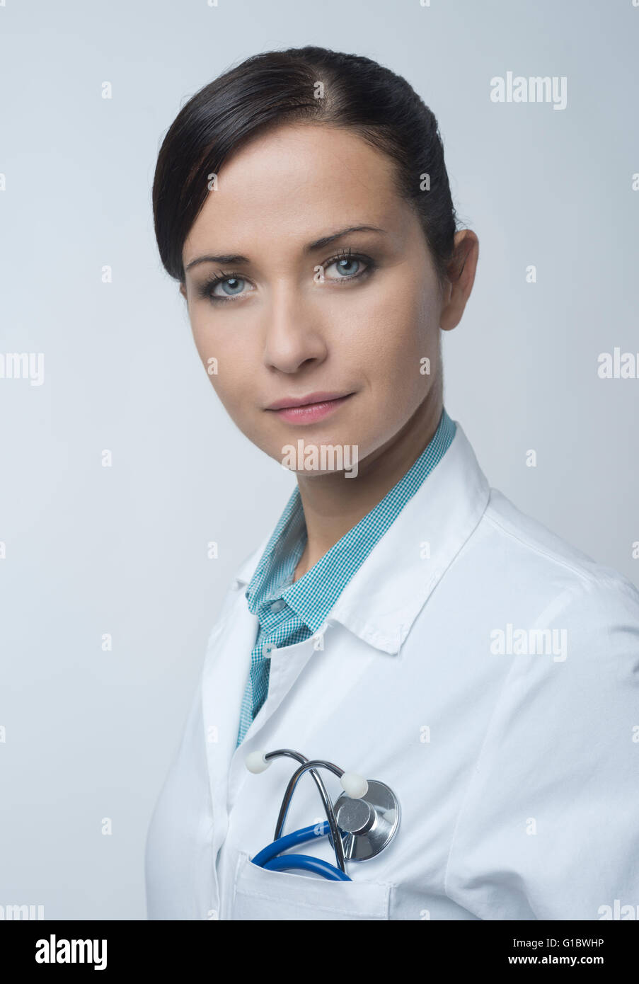 Lächelt zuversichtlich Ärztin Portrait mit Kittel und Stethoskop. Stockfoto