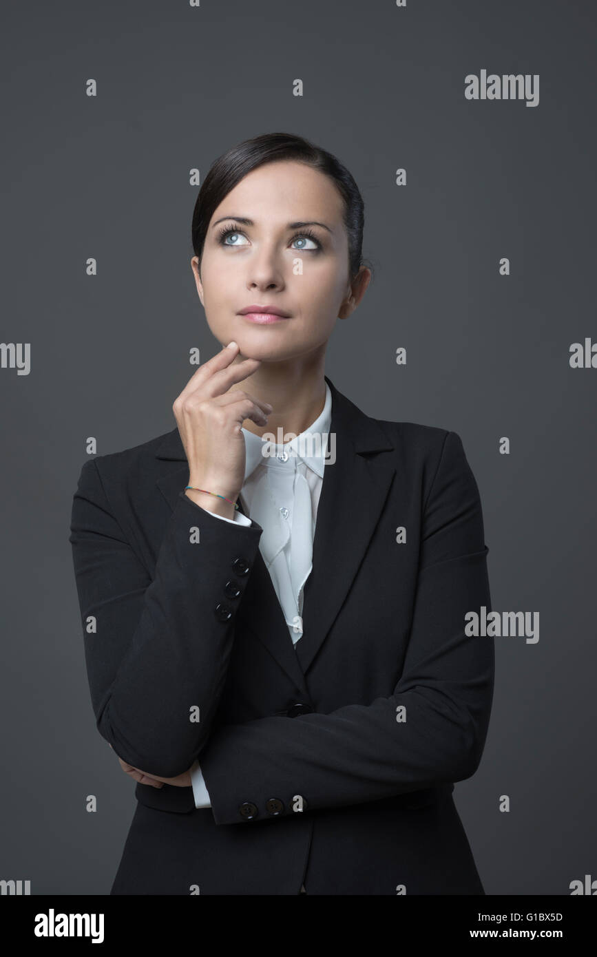 Attraktive nachdenklich Geschäftsfrau mit Hand am Kinn wegsehen. Stockfoto