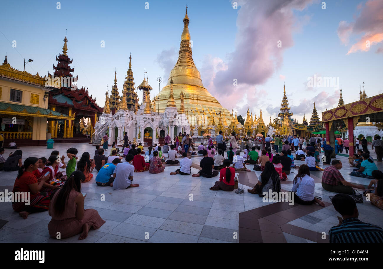 Menschen an der Shwedagon Paya in Yangon während des Sonnenuntergangs Stockfoto
