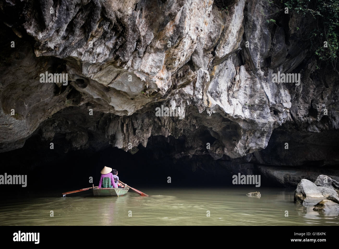 Menschen, die ihren Weg durch Ruderboot in einer Höhle in Ninh Binh Province, Vietnam Stockfoto