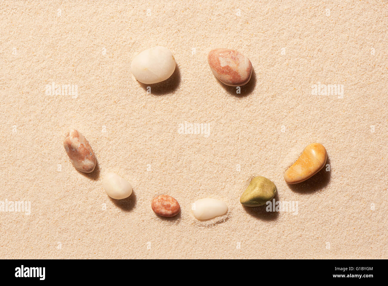 Lächeln des Meeres Steinen auf Sand. Sommer Strand Hintergrund. Ansicht von oben Stockfoto
