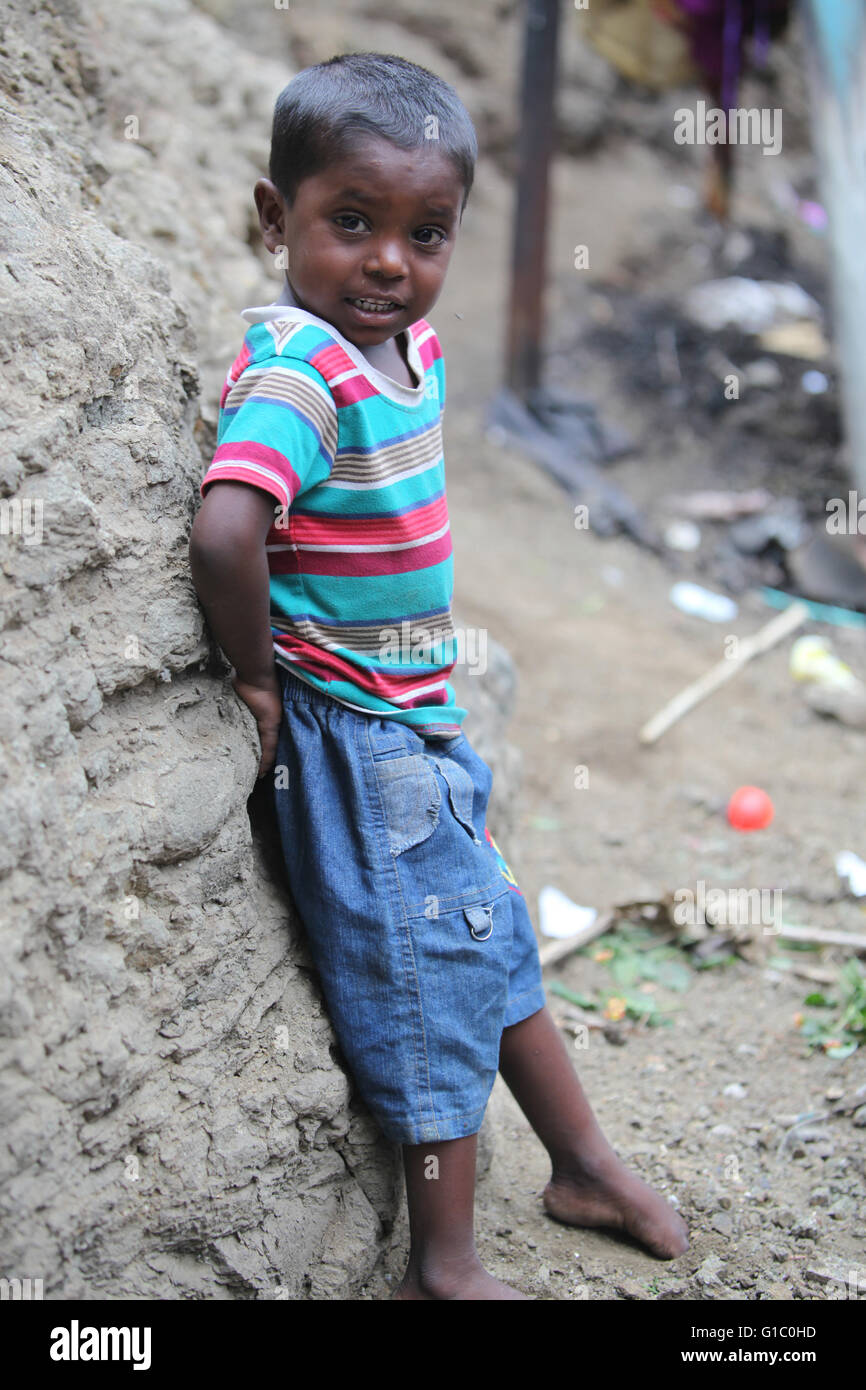 Pune, Indien - 16. Juli 2015: Ein armer indischer Junge stehend auf einer Baustelle, wo seine Eltern in Indien arbeiten Stockfoto