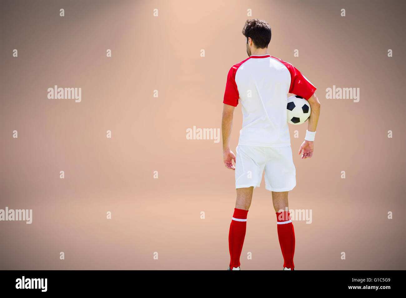 Zusammengesetztes Bild der Rückansicht der Mann Fußball Uniform trägt und hält Fußball Stockfoto