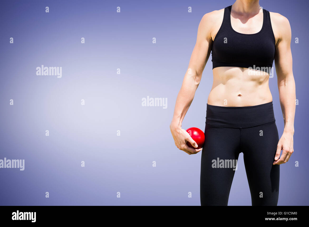 Zusammengesetztes Bild der sportlichen Frau hält eine rote Kugel Stockfoto