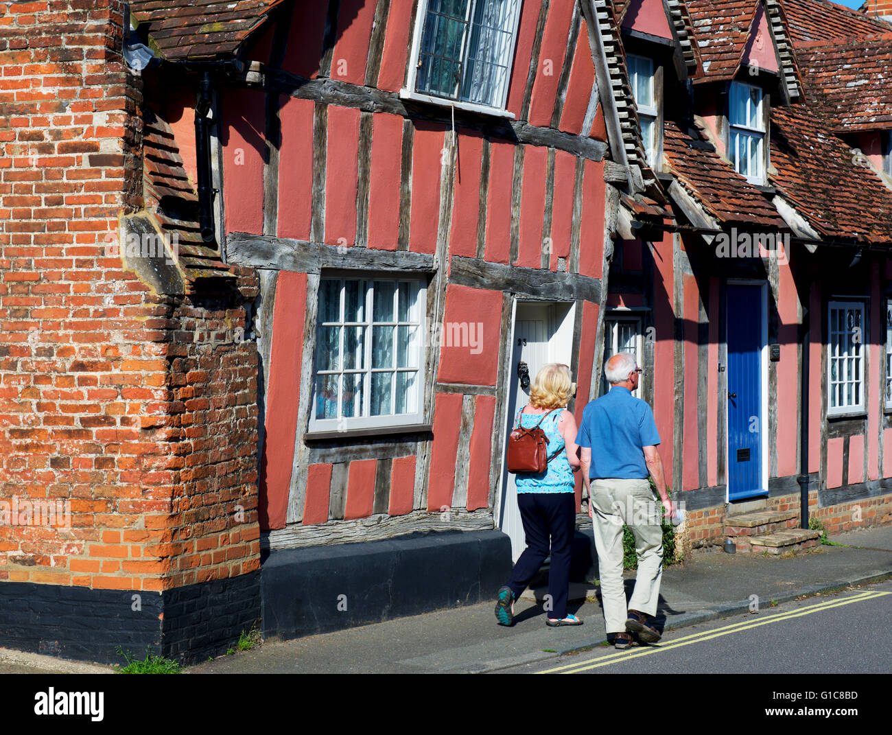 Paar, vorbei an mittelalterlichen Fachwerkhäuser im Dorf Lavenham, Suffolk, England UK Stockfoto