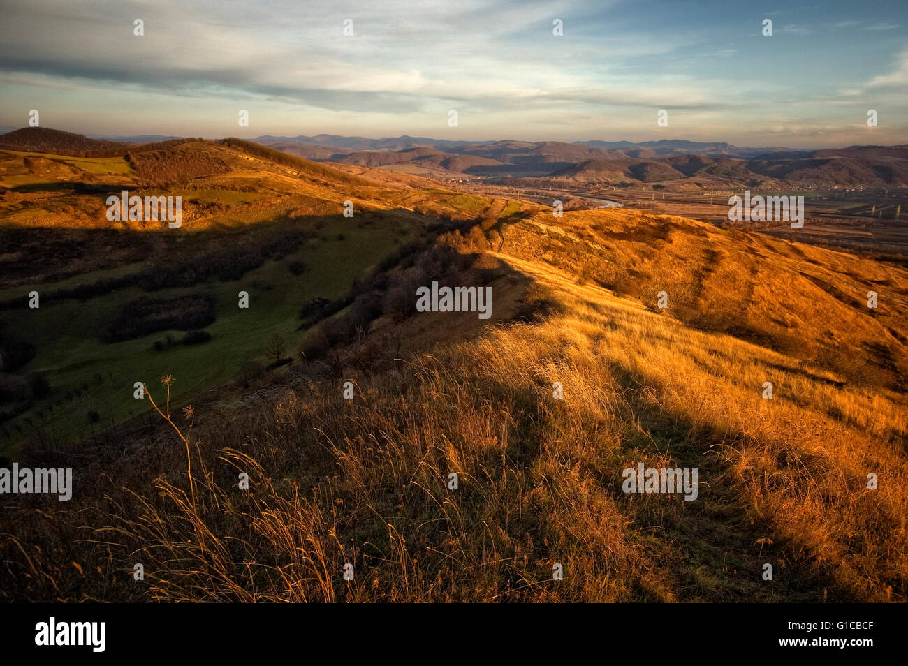 herbstliche Landschaft mit trockenen Gräsern auf Hügel bei Sonnenuntergang Stockfoto